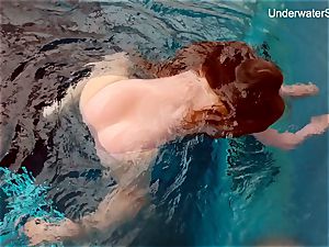 red-haired Simonna showcasing her assets underwater